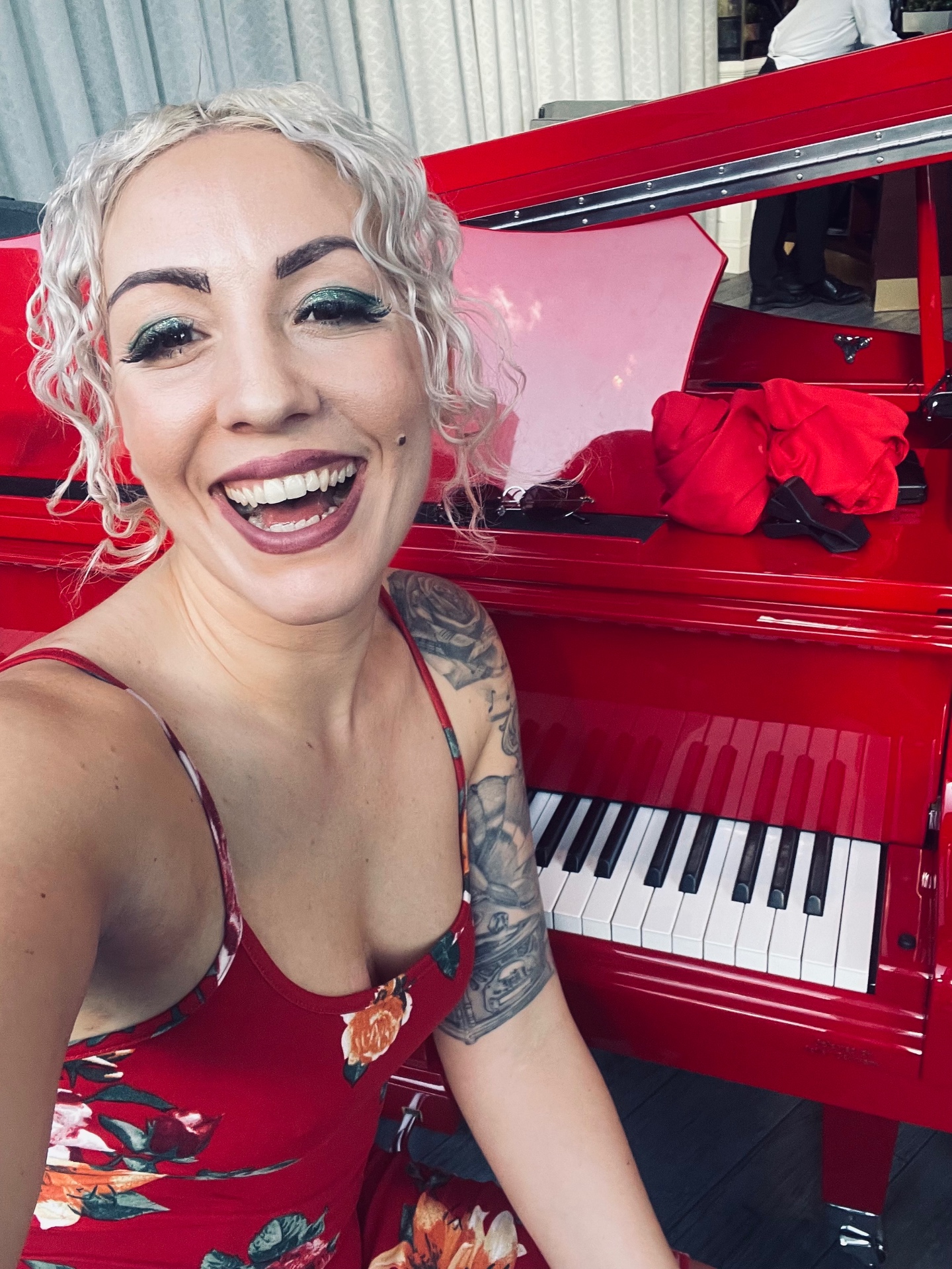 Clarissa smiling at the red piano